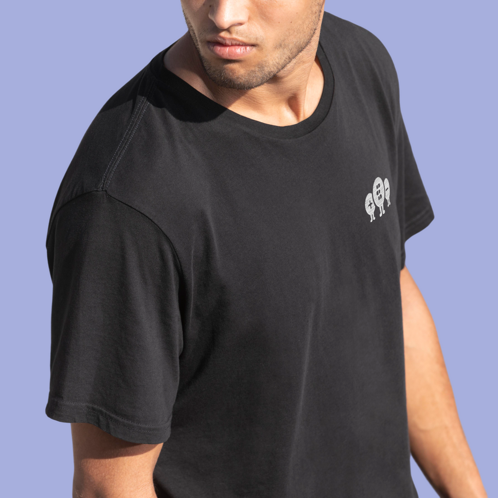 Man wearing a black t-shirt with quantum tryon embrodery on a blue background